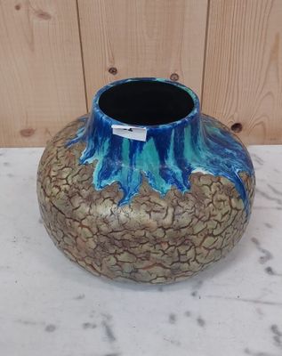 un vase bleu et marron posé sur une table