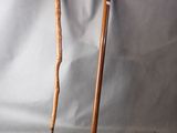 two wooden walking canes sitting next to each other on a gray background