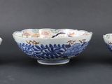 three blue and white bowls sitting on top of a black table