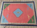 a red and blue rug on a wooden floor