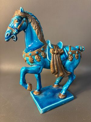 statue of a blue horse on a blue base with a brown mane