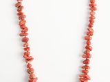 un collier de perles de corail rouge sur fond blanc