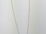 a silver necklace with an orange stone and a bird on it
