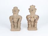 pair of ancient figurines of a man and a woman on a white background
