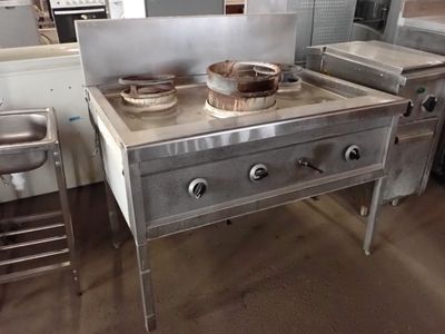 une cuisinière sur laquelle est posée une marmite dans une cuisine