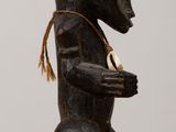 a wooden statue of a bear with a hat on it ' s head