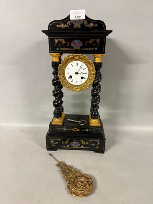 a black and gold clock sitting on a white surface