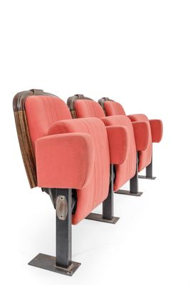 a row of red seats in an empty theater