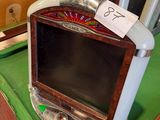 une petite télévision posée sur une table verte