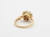 a close up of a gold ring with a brown stone