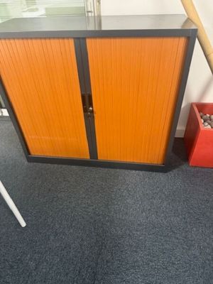 an orange cabinet with a baseball bat on top of it