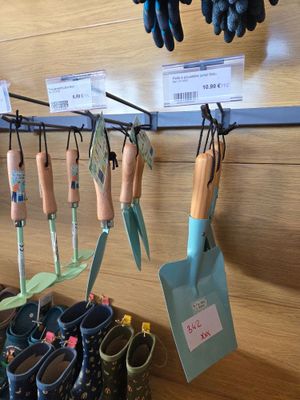 many pairs of gardening gloves hanging on a rack