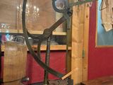 a glass display case with a wooden barrel and a coat rack