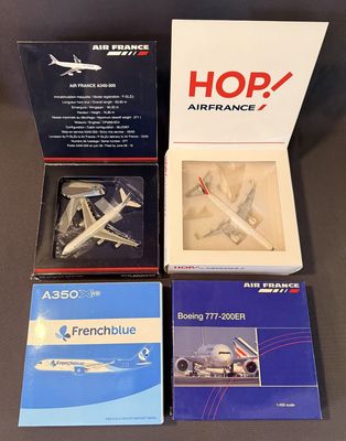 Quatre maquettes d'avions sont posées dans une boîte sur une table