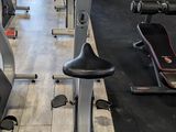 a gym room with a row of stationary exercise bikes in it