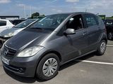 Une Mercedes Classe B garée sur un parking, avec d'autres voitures en arrière-plan