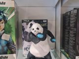a display case with a panda bear and various games on it