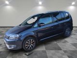 une Volkswagen Touran bleue garée sur un sol en carrelage à damier
