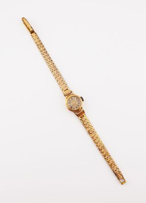 a gold wrist watch on a white surface