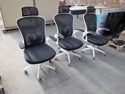 four black office chairs with white arms and wheels in a room