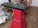 une table rouge au plateau noir, au milieu d'une pièce