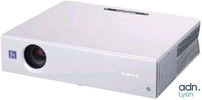 un projecteur blanc posé sur une table blanche