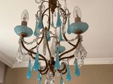 un lustre dont des gouttes de verre bleues pendent du plafond