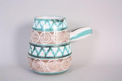 a blue and white pitcher with a handle on a table
