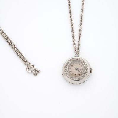 une image représentant une montre de poche en argent avec sa chaîne, posée sur une surface blanche
