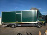 a green truck that is parked in a parking lot