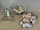 trois figurines en porcelaine représentant une femme et une théière posées sur une table