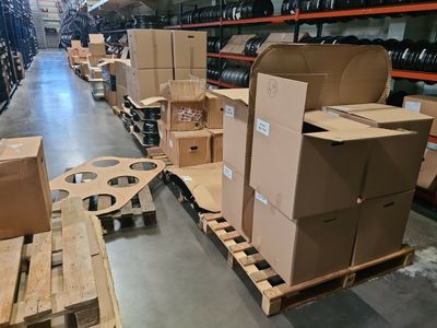 de nombreux cartons sur des palettes dans un grand entrepôt