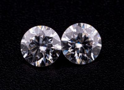 une paire de diamants taille ronde sur un fond noir