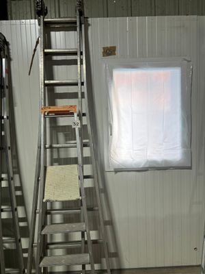 deux échelles posées près d'une fenêtre dans une pièce