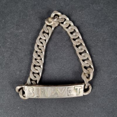 a close up of a silver chain bracelet with the word believe on it