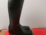 black leather boots with zippers on top of a red box