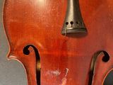a close up of a violin with a bell on the back of it