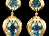 une photo d'une paire de boucles d'oreilles en topaze bleue et or jaune