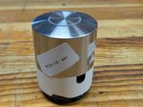 a silver speaker sitting on top of a wooden table