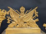 a gold statue of a woman holding a sword on a table