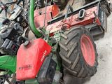 un tracteur vert et un tracteur rouge par terre