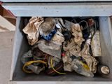 a metal box filled with assorted items on the floor