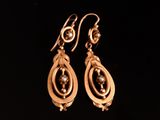 une paire de boucles d'oreilles en or sur fond noir
