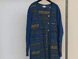 une robe bleue suspendue à un portant dans une pièce