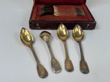 five spoons and two spoons sitting in a case
