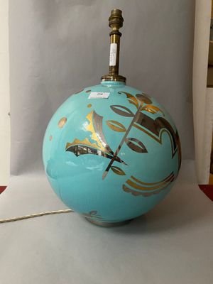 a blue ball with gold designs on it on a table