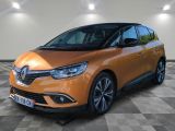 La voiture orange est garée sur un sol en carrelage à damier.