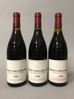 trois bouteilles de vin rouge posées sur une table l'une à côté de l'autre