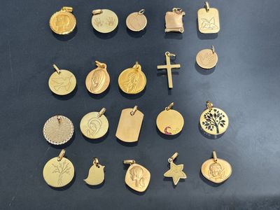 many different types of gold pendants on the table