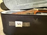 a suitcase with a guitar inside of it on the floor